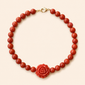 שרשרת CORAL ROSE מאבני קורל עם ורד אדום על רקע שמנת