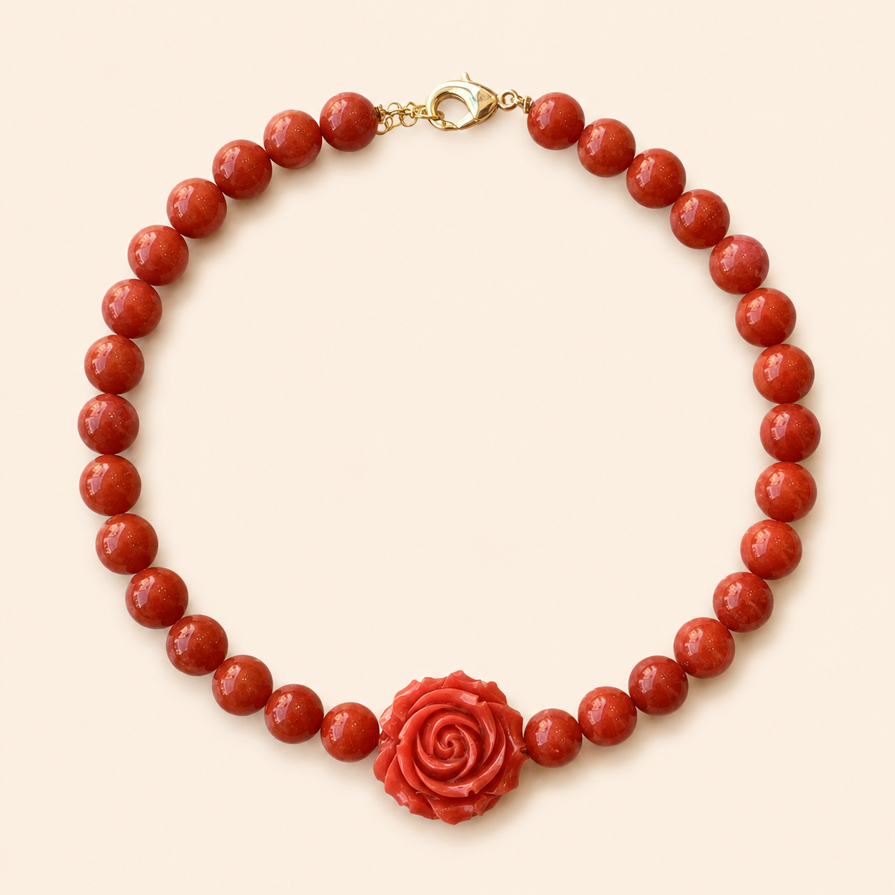 שרשרת CORAL ROSE מאבני קורל עם ורד אדום על רקע שמנת