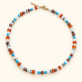 שרשרת OCEAN EMBER בשילוב אבנים בגוני כחול, כתום וחום על רקע שמנת