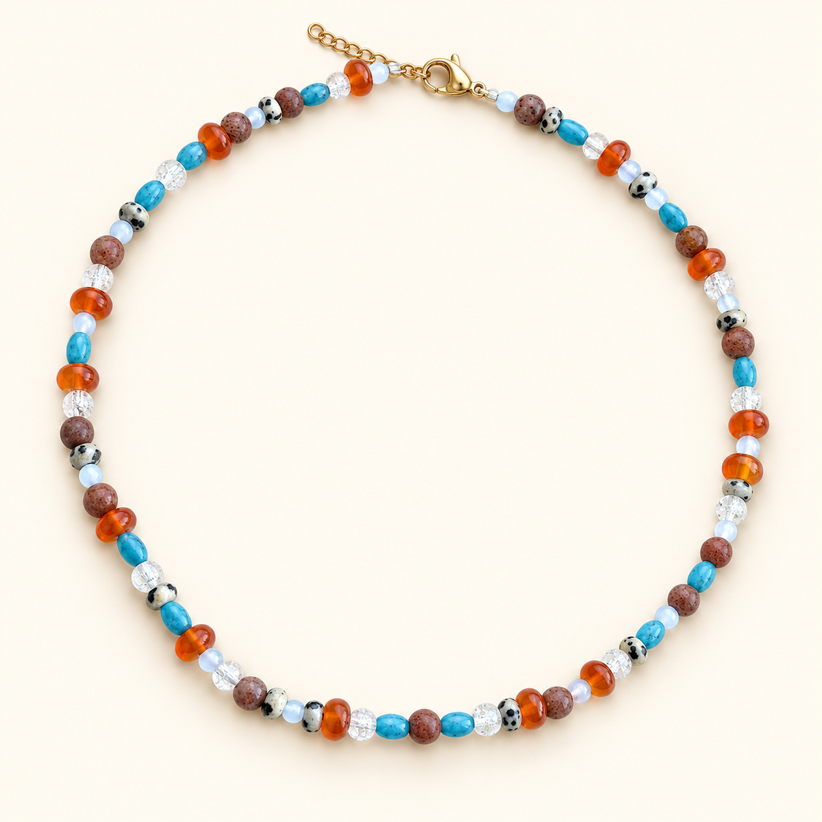 שרשרת OCEAN EMBER בשילוב אבנים בגוני כחול, כתום וחום על רקע שמנת