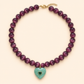 שרשרת PLUM HEART מאבני עין החתול סגולות עם תליון לב אמזוניט וזירקון ירוק בצורת לב על רקע שמנת
