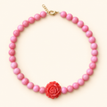 ROSIE BLOOM Necklace — שרשרת ג׳ייד ורודה עם פרח אדום במרכז על רקע שמנת