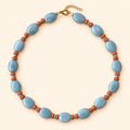 SKY CORAL Necklace — שרשרת אבנים כחולות עם חרוזים כתומים וטורקיז על רקע שמנת